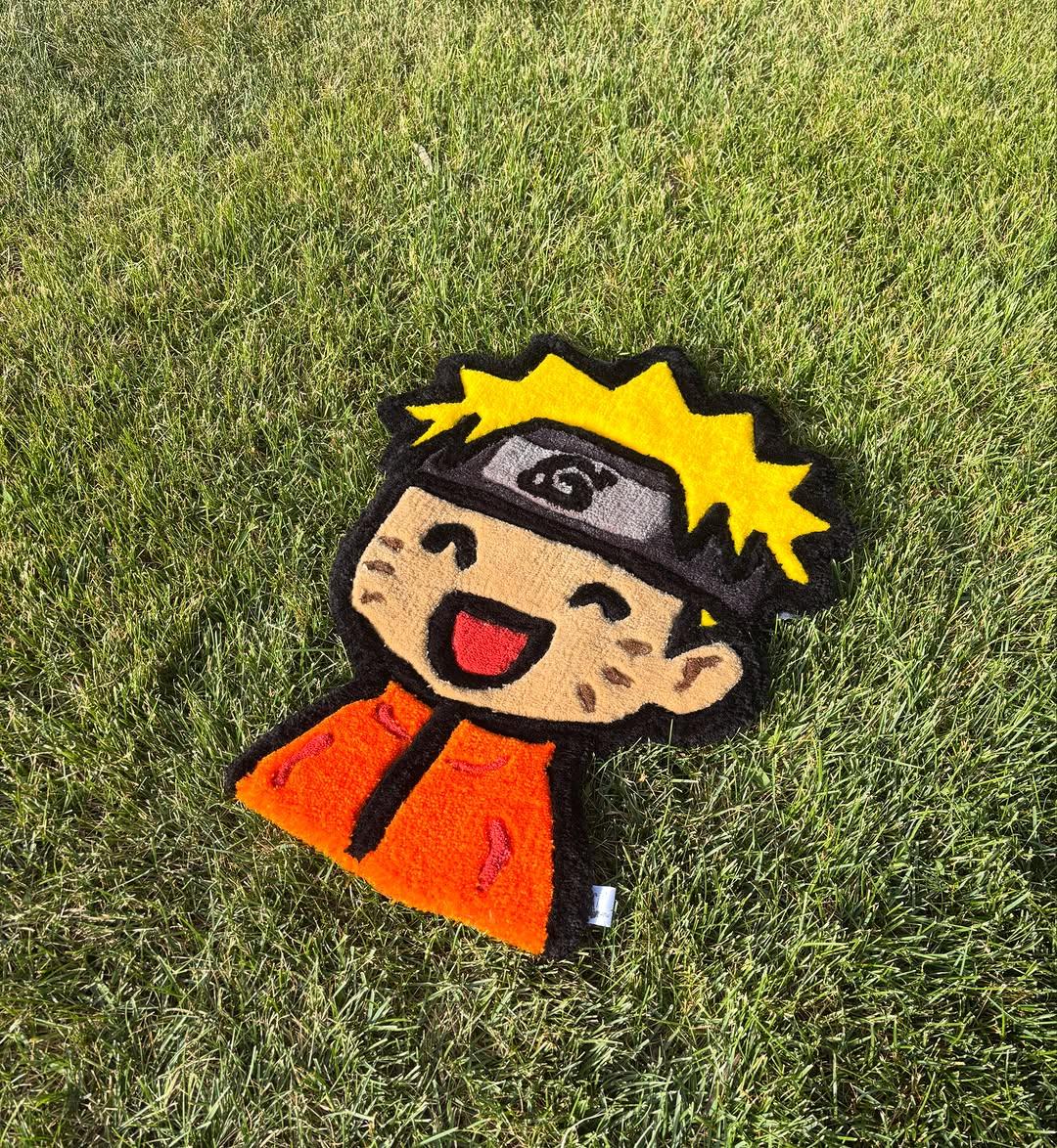 Hand-tufted anime character rug in orange and yellow with a white pile outline