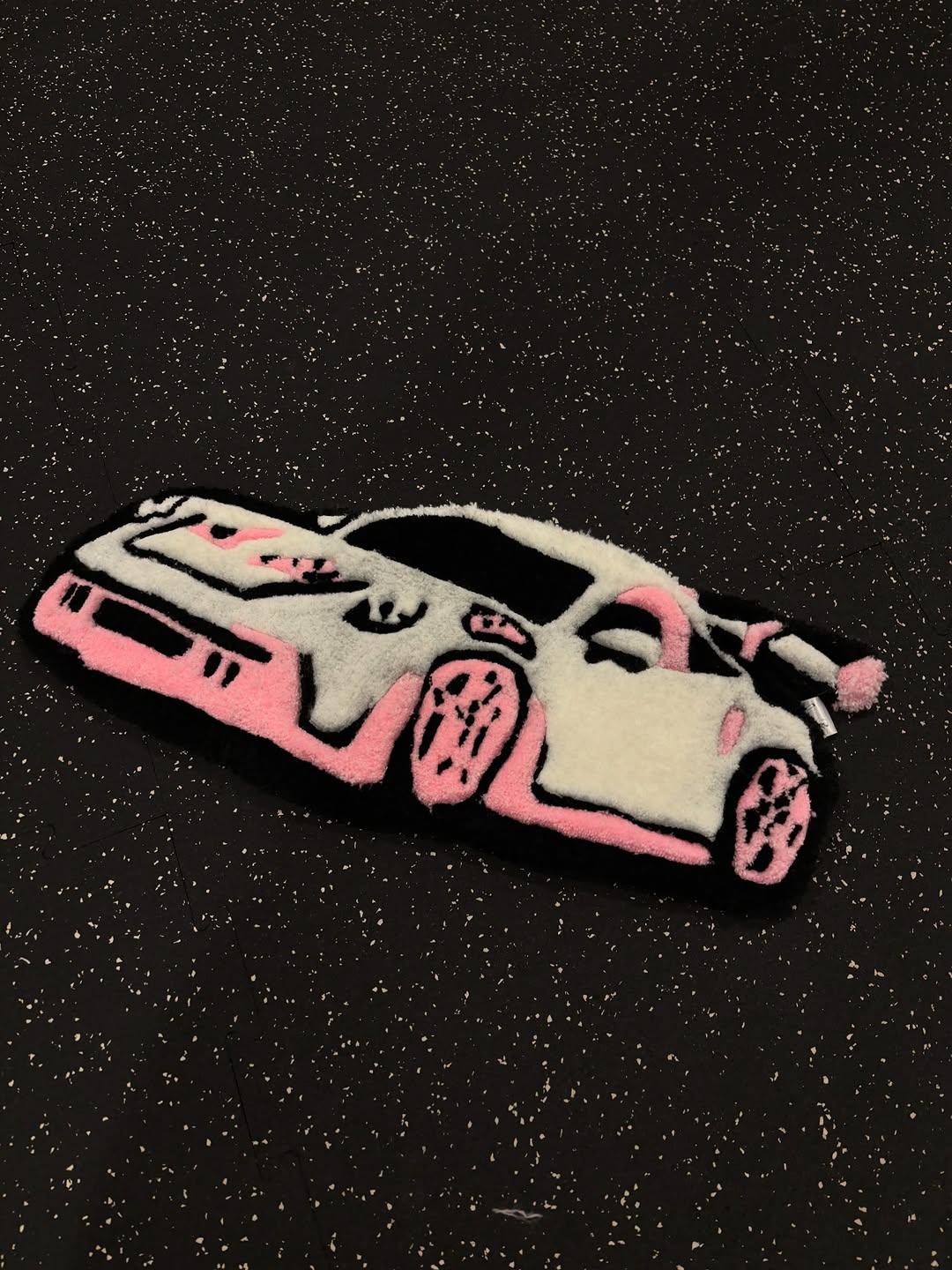 Hand-tufted cream and pink sports car rug on a dark speckled floor
