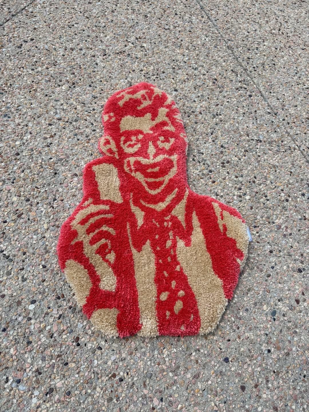 Hand-tufted portrait rug worked in red and cream, laid on concrete