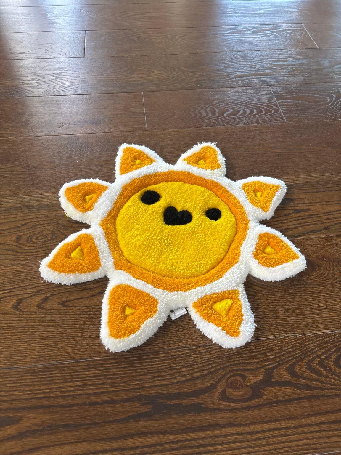 Hand-tufted smiling sun rug in yellow and orange with a white tufted border
