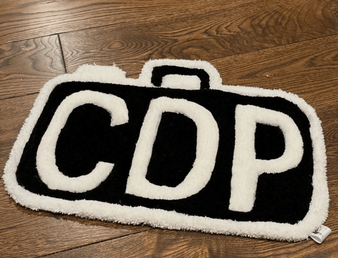Hand-tufted black and white lettering rug photographed on a wood floor