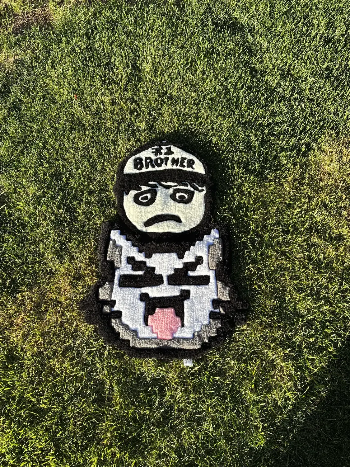 The cat face rug beside a second character rug with a BROTHER cap