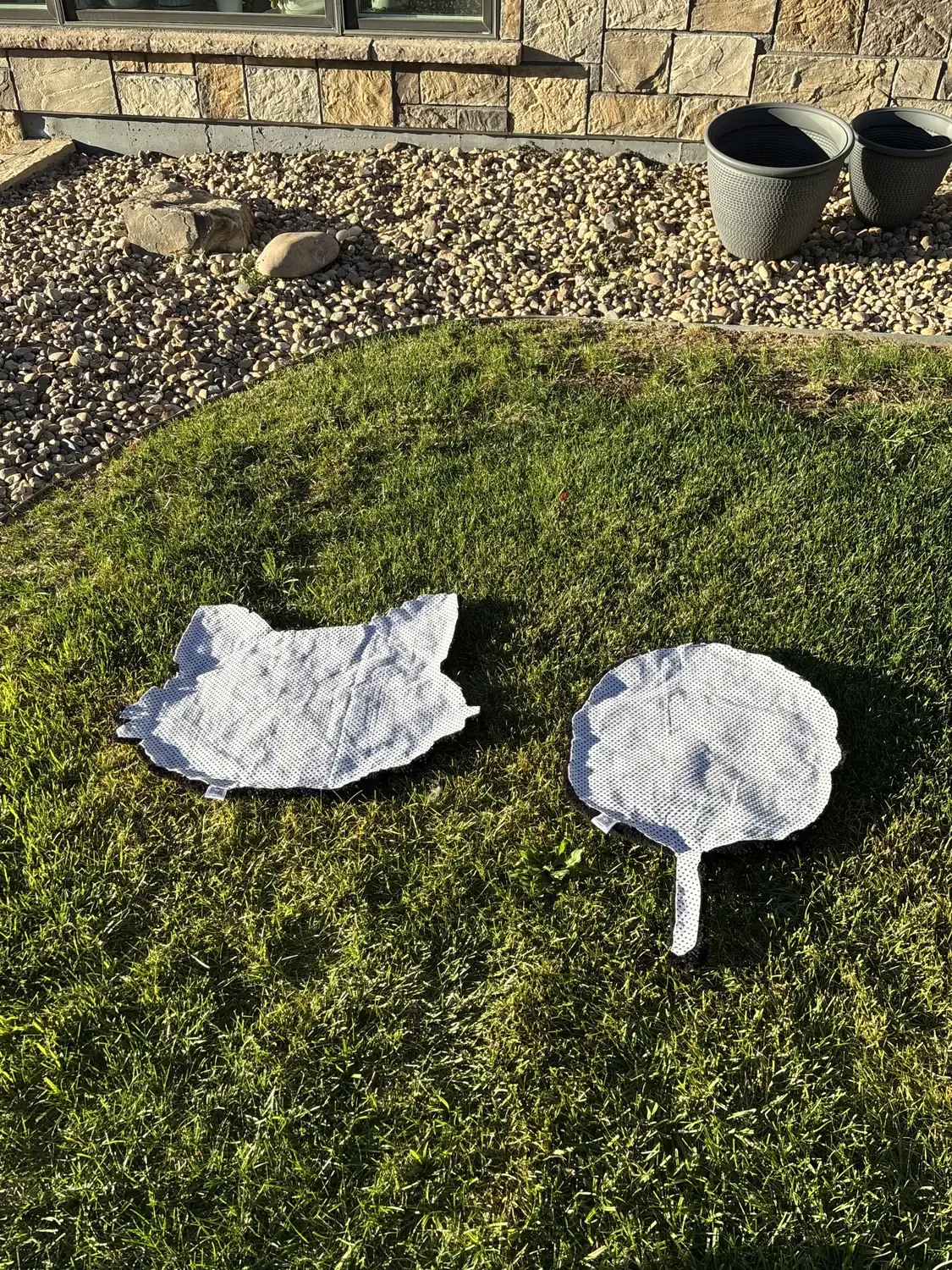 The reverse sides of two custom rugs laid out on grass