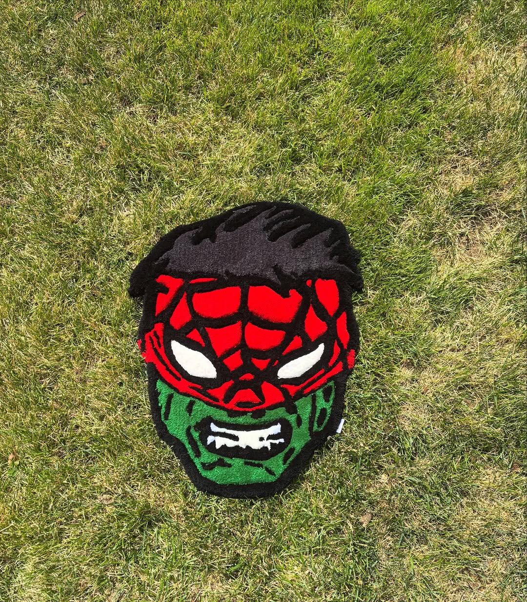 Hand-tufted mask rug, half red webbed mask and half green, photographed on grass